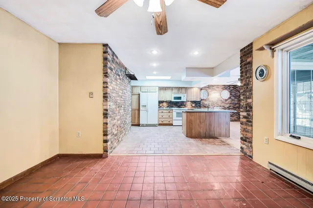 a kitchen with stainless steel appliances kitchen island granite countertop a refrigerator and a sink