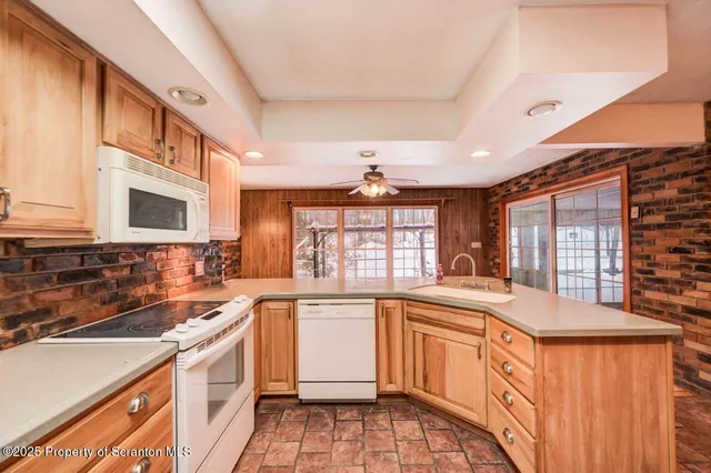 a large kitchen with kitchen island granite countertop a large window cabinets and stainless steel appliances