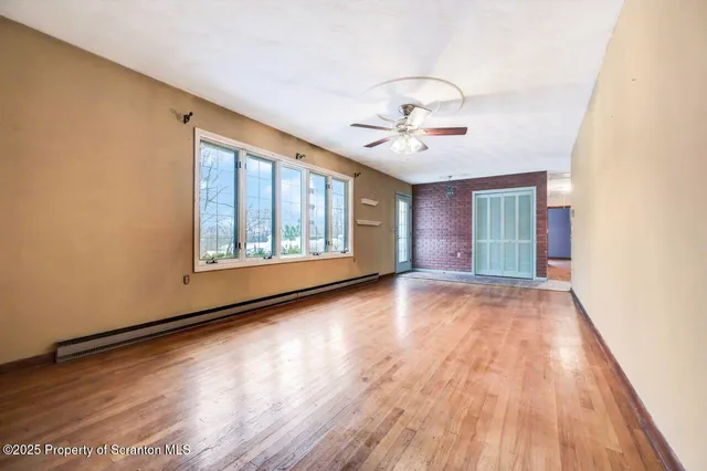 a view of a livingroom with wooden floor and a ceiling fan