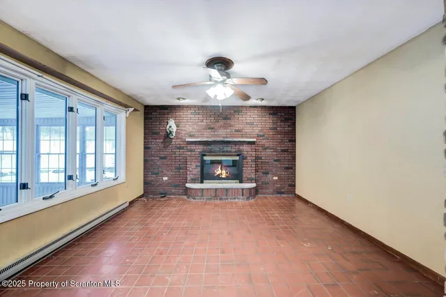 a view of an empty room with a fireplace and a window