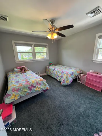 a bedroom with two beds next to a window
