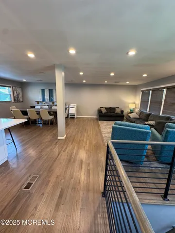 a view of a living room and kitchen with furniture wooden floor and windows