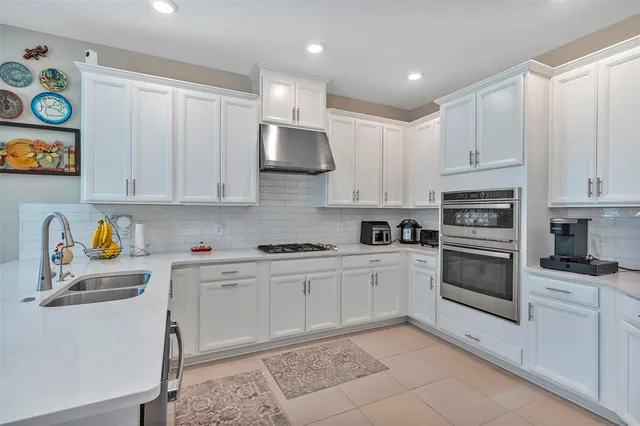 a kitchen with cabinets stainless steel appliances and a window