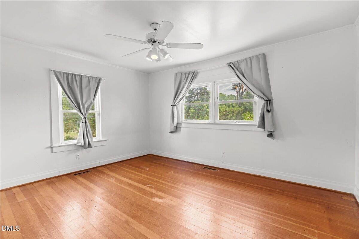 109 Little Ponderosa Road Macon, NC 27551 - Photo 17 of 32 a view of an empty room with wooden floor and a window