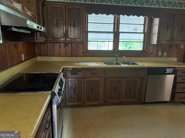 a kitchen that has a sink and a stove in it