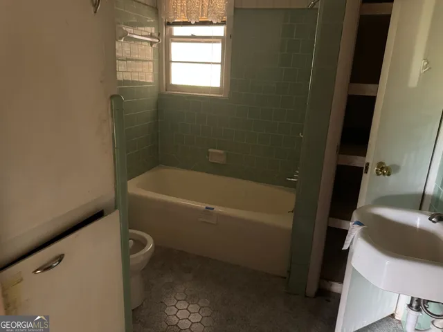 a white bath tub sitting next to a white toilet