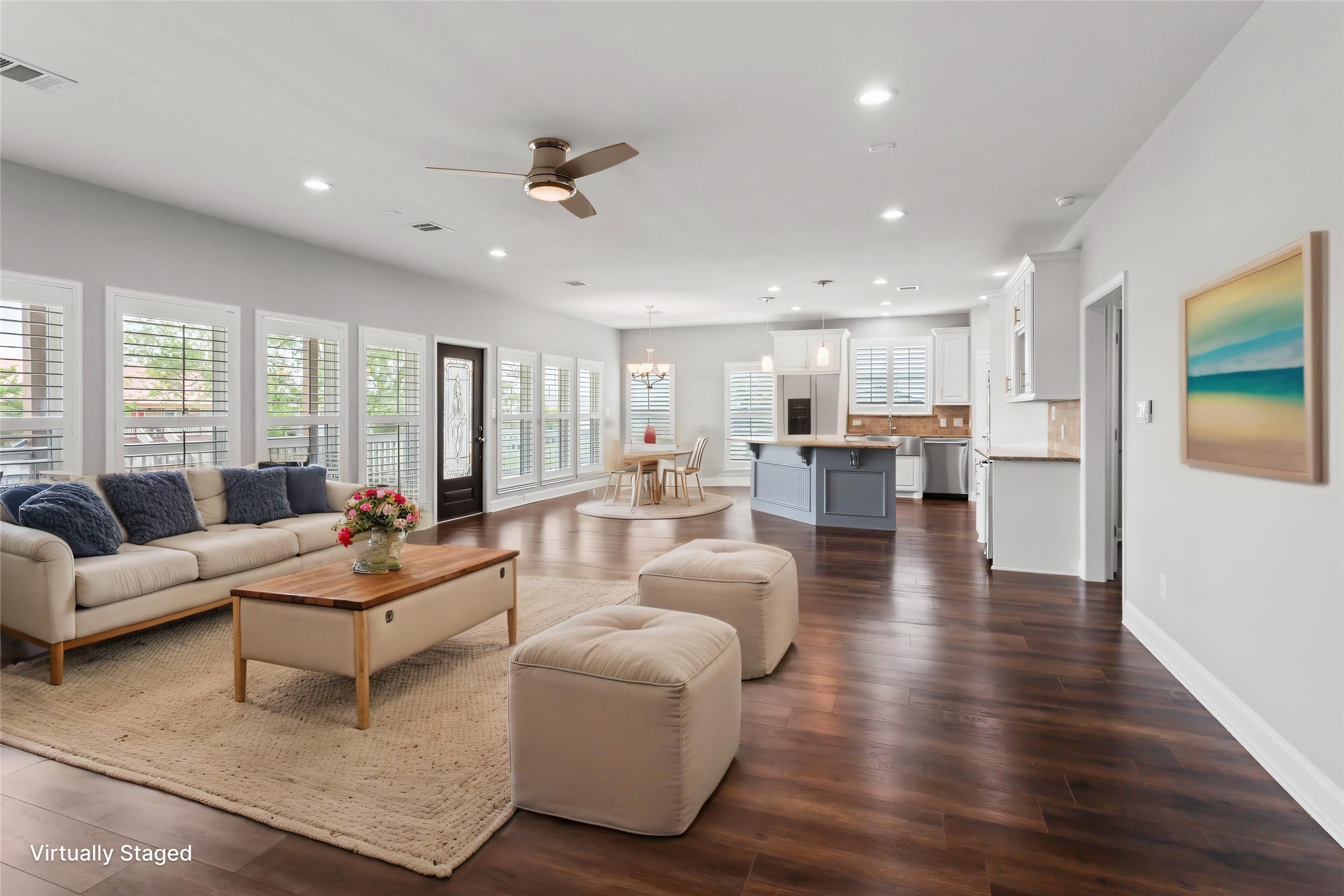 610 South Shady Lane La Porte, TX 77571 - Photo 13 of 50 This photo showcases a bright, open-concept living area with modern finishes. The space features a cozy seating area, large windows with shutters, recessed lighting, and a ceiling fan.