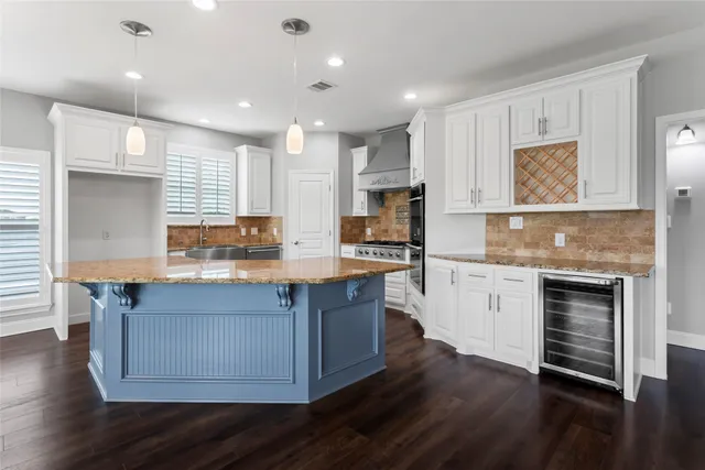 a kitchen with stainless steel appliances granite countertop a stove a sink and a refrigerator