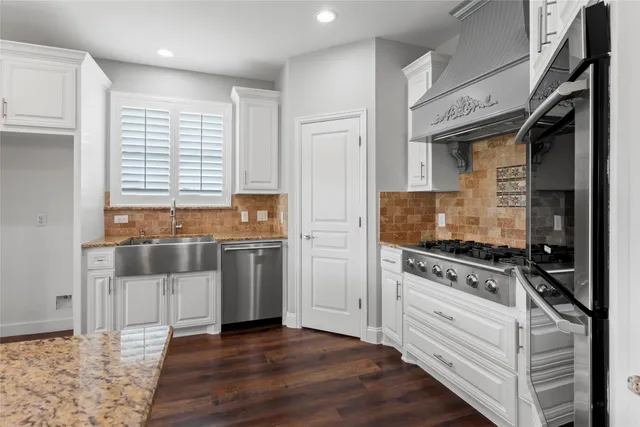 a kitchen with a stove and white cabinets