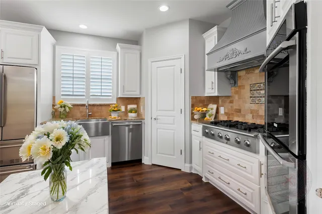 a kitchen with a stove a refrigerator and a dining table with wooden floor