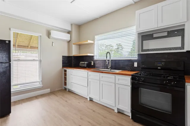 a kitchen with granite countertop a stove a sink and a microwave