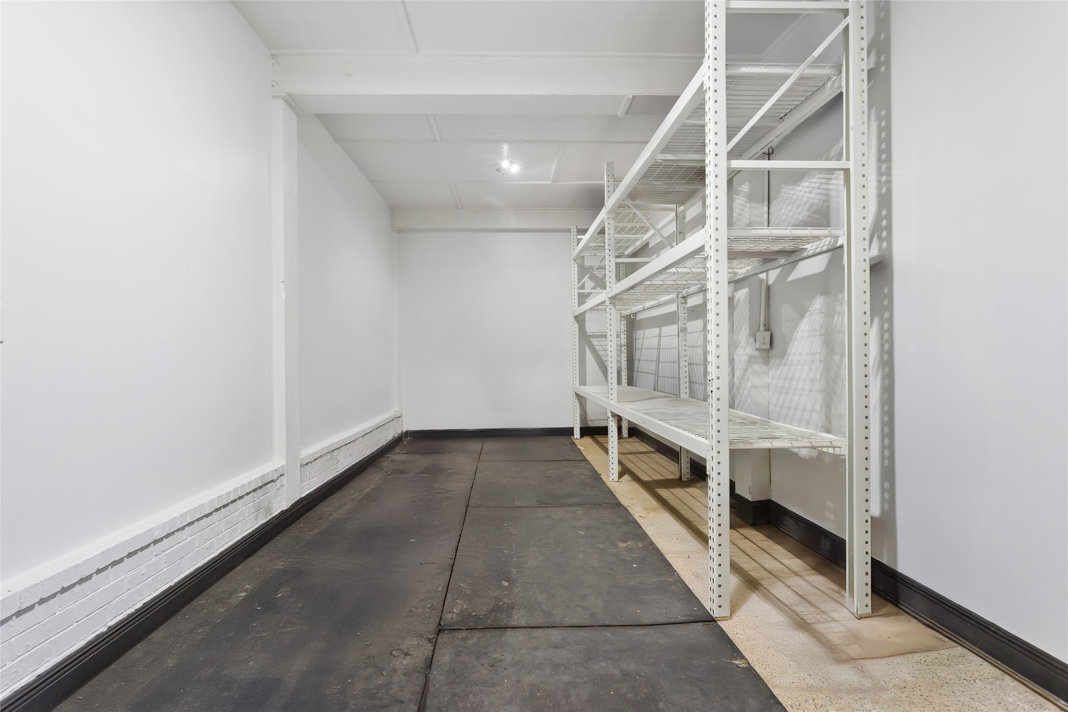 610 South Shady Lane La Porte, TX 77571 - Photo 45 of 50 This photo showcases a spacious storage room with white walls and ceiling. It features sturdy metal shelving units for ample storage and a solid floor, making it ideal for organizing belongings or supplies. Formally used as a gym.