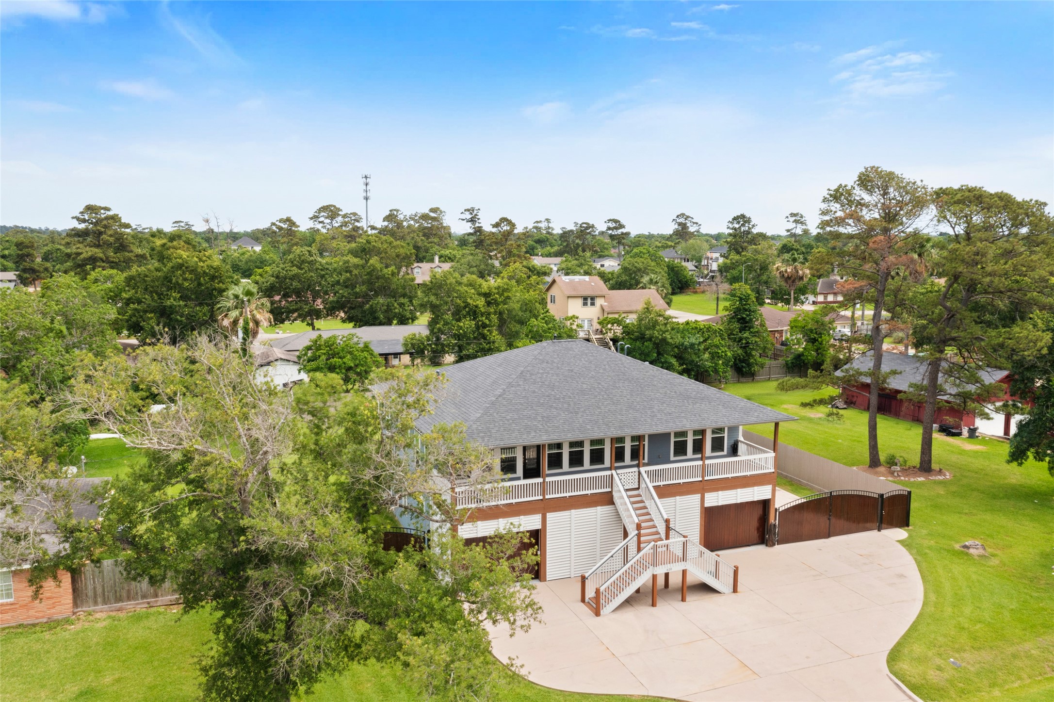 610 South Shady Lane La Porte, TX 77571 - Photo 5 of 50 This elevated home features a large driveway and inviting porch, set amidst a lush, green neighborhood with ample trees and spacious lawns. Ideal for those seeking a serene and picturesque setting.