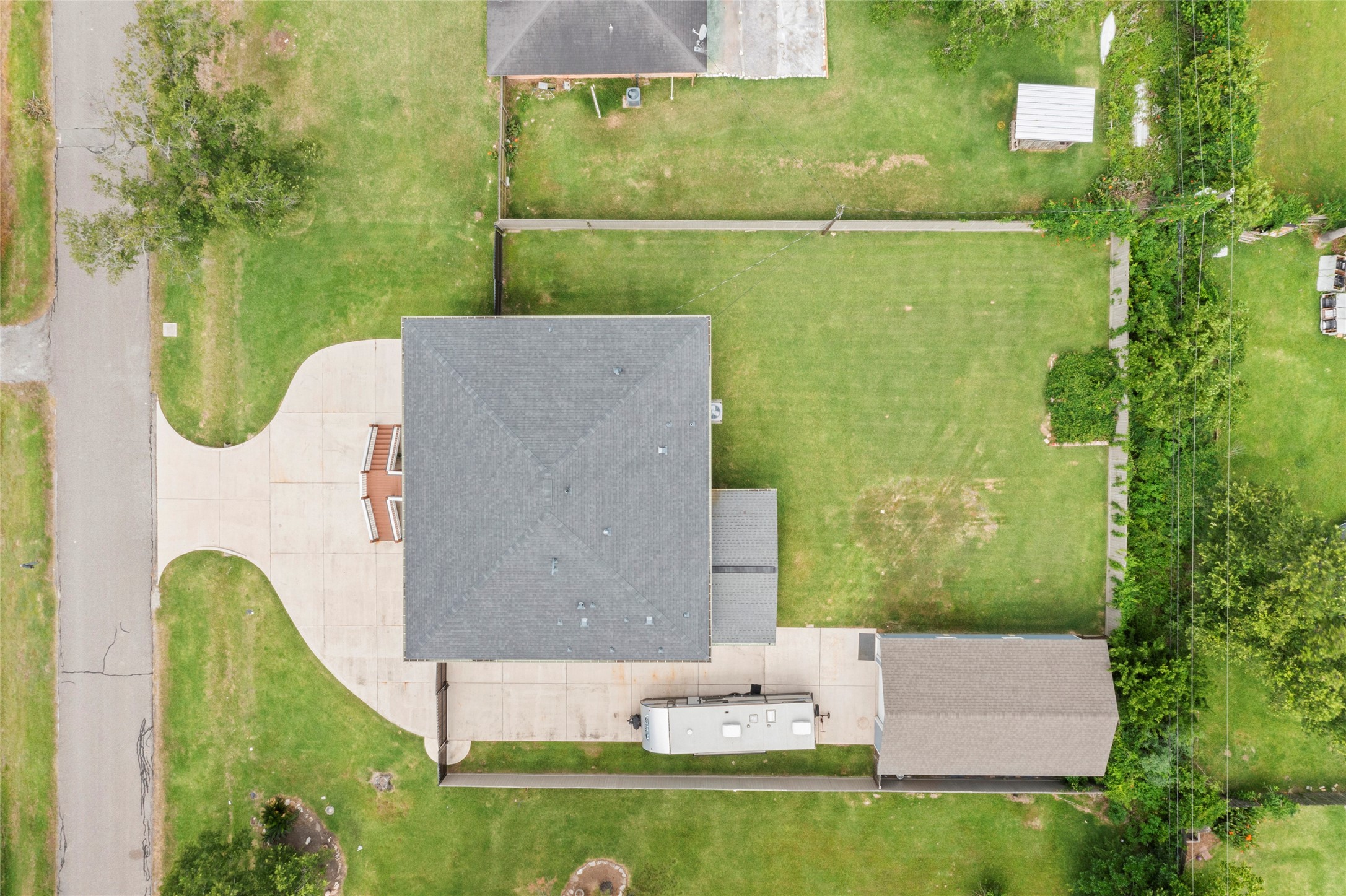 610 South Shady Lane La Porte, TX 77571 - Photo 6 of 50 This aerial view shows a spacious property with a large, neatly maintained lawn and a driveway leading to a 630 SQFT detached garage/shop. There's ample space in the backyard for a pool.