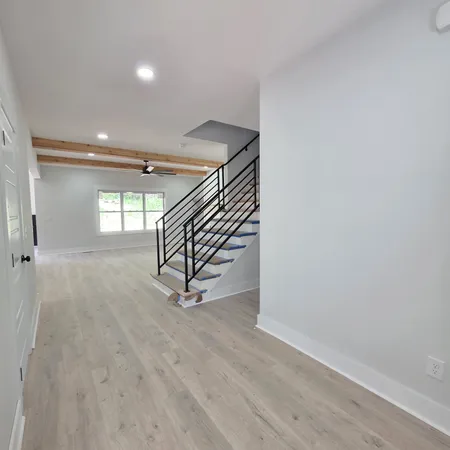 an empty room with a ceiling fan and a large window