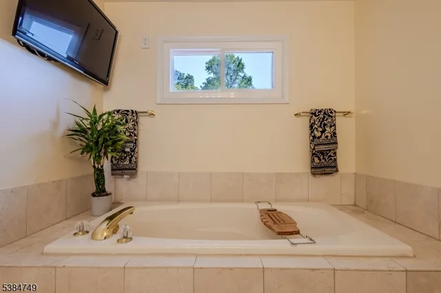 a bathroom with a bathtub and a window