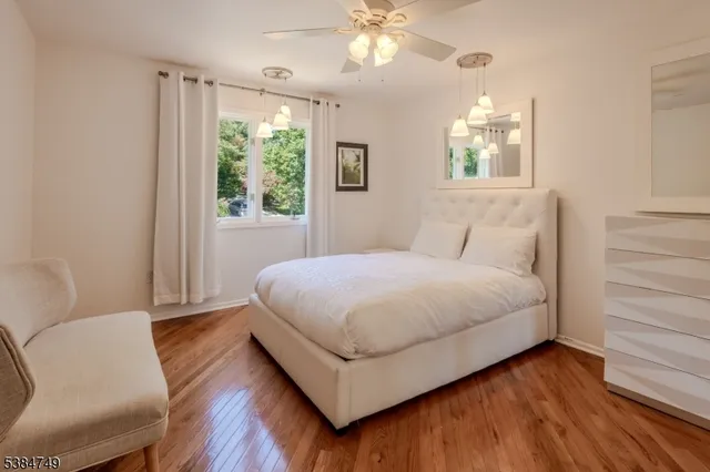 a bedroom with a large bed chandelier and a window