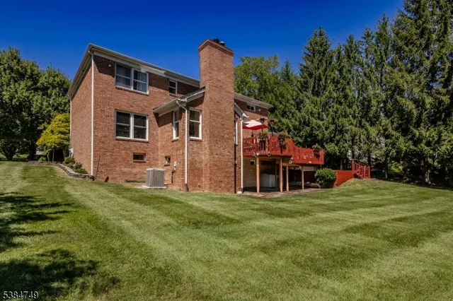 a front view of house with yard and trees in the background