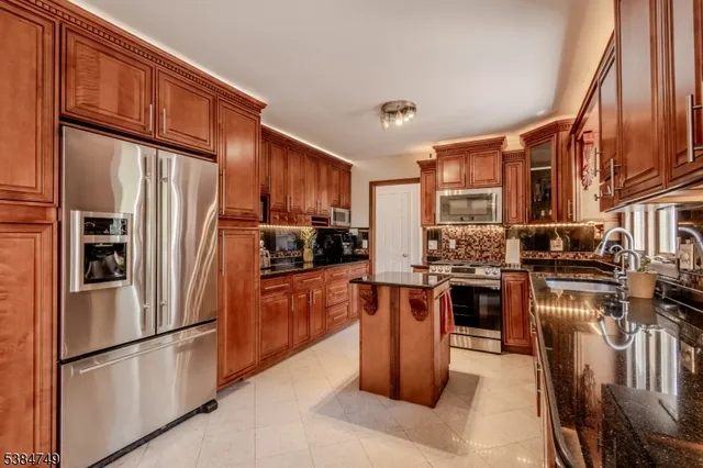 a kitchen with stainless steel appliances granite countertop a refrigerator stove microwave and sink