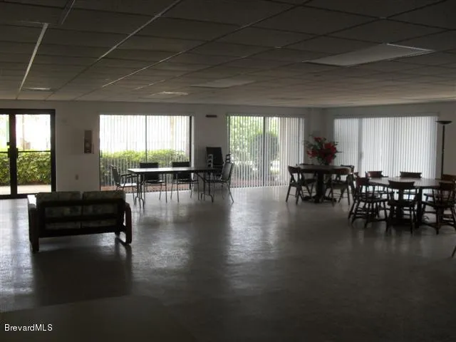 a living room with couches and a dining table with wooden floor