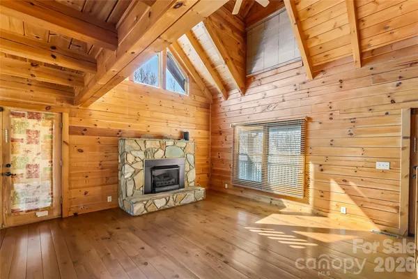 a view of a livingroom with wooden floor and a fireplace