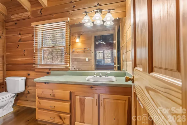 a bathroom with a granite countertop sink and a large mirror next to a window