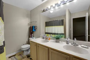 a bathroom with a granite countertop sink a toilet and a mirror