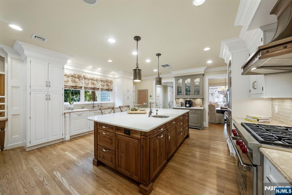 203 Heights Road Ridgewood, NJ 07450 - Photo 21 of 41 a large kitchen with kitchen island a stove a sink dishwasher and a dining table with wooden floor