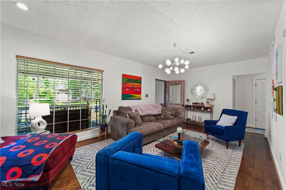 14420 Superior Road Cleveland, OH 44118 - Photo 6 of 44 Living room with wood finished floors, a textured ceiling, a chandelier, and baseboards