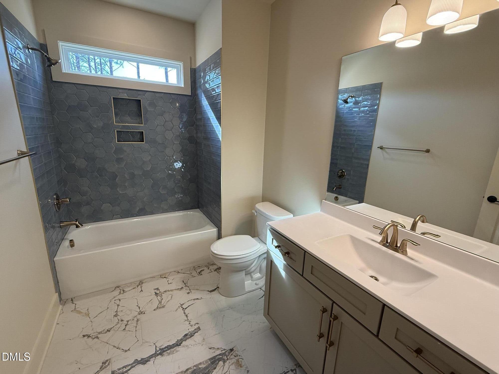 12601 Burgess Road Middlesex, NC 27557 - Photo 24 of 27 a bathroom with a sink a toilet a mirror a bathtub and shower