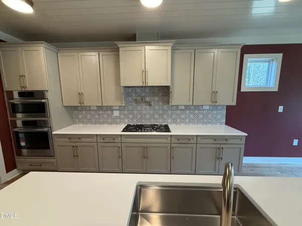 a kitchen with kitchen island a stove and a sink