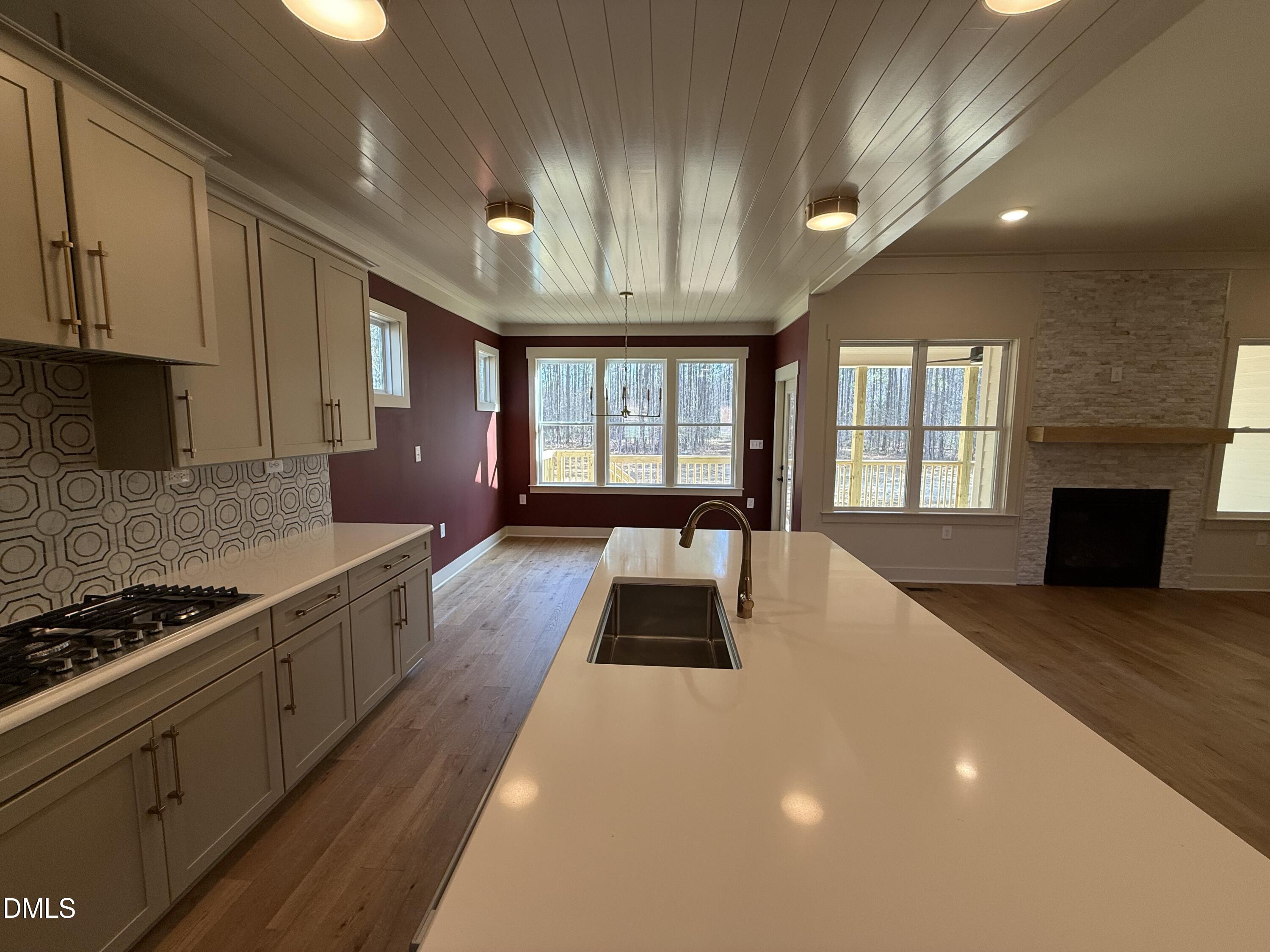 12601 Burgess Road Middlesex, NC 27557 - Photo 10 of 27 a large white kitchen with granite countertop a stove a sink a window and white cabinets