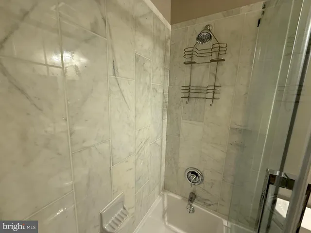 a bathroom with a granite countertop sink toilet a mirror and shower