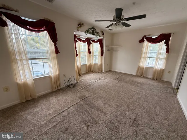 a view of a livingroom with a ceiling fan and window