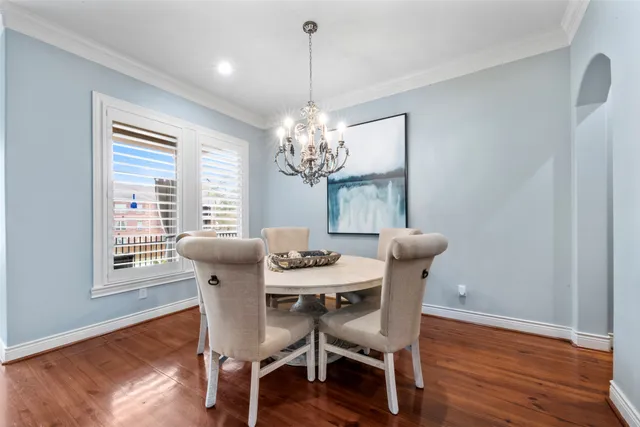 a dining room with furniture a chandelier and wooden floor