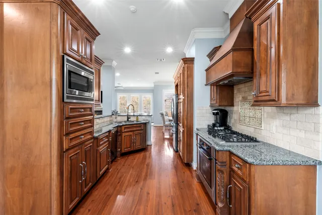 a kitchen with granite countertop stainless steel appliances and wooden cabinets