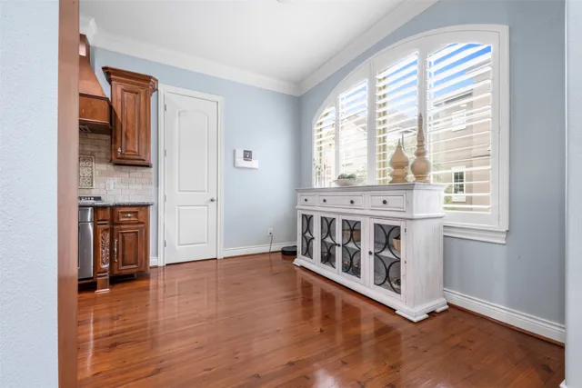 a view of an empty room with window and wooden floor