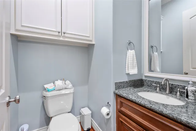 a bathroom with a granite countertop toilet sink and mirror