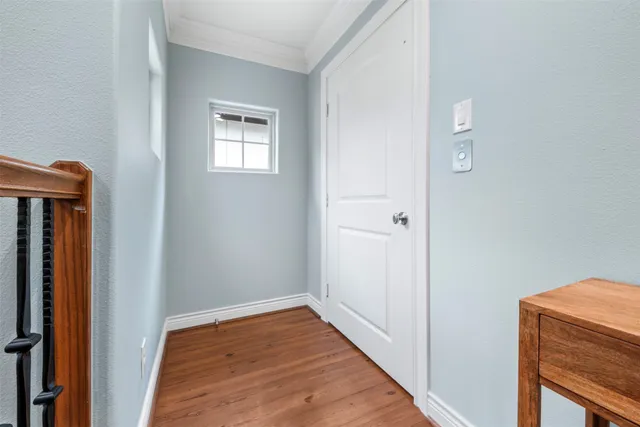 a view of a hallway with wooden floor and a window