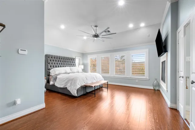 a bedroom with a large bed and a flat tv screen on dresser