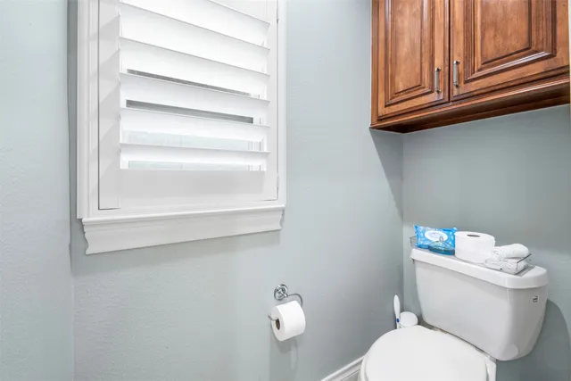 a white toilet sitting next to a window