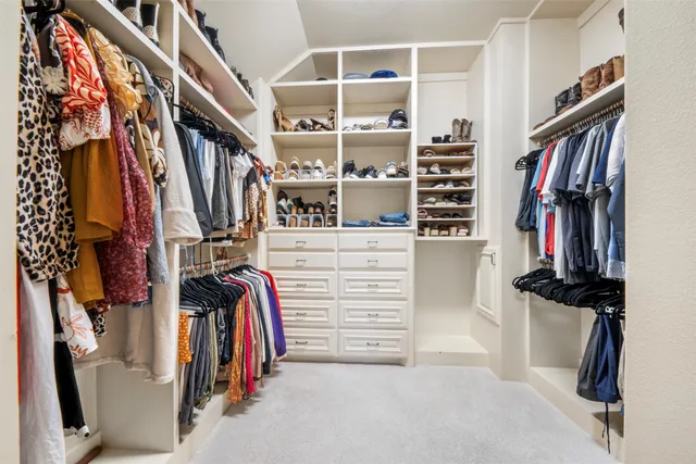 a view of walk in closet with clothes and shoes