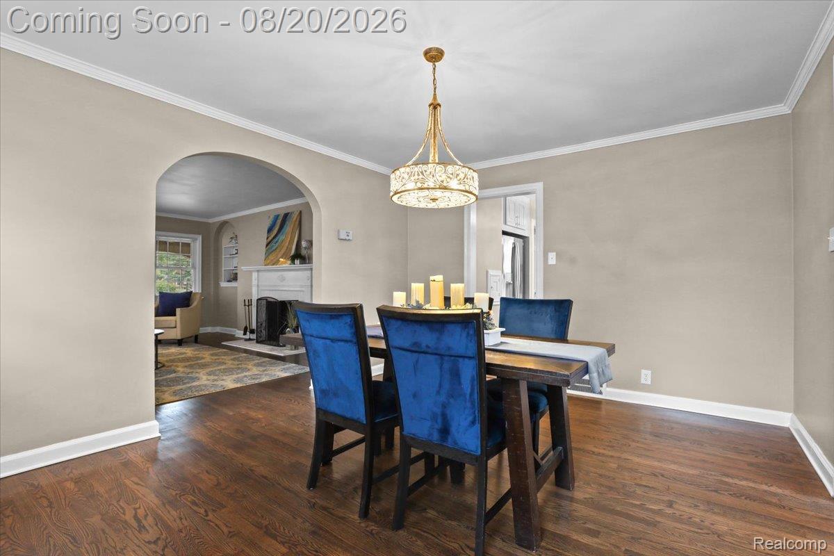 429 Moran Road Grosse Pointe, MI 48236 - Photo 6 of 36 Hardwood flooring, crown molding, arched entryway, and a decorative chandelier
