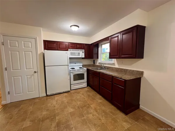 a kitchen with wooden cabinets and white appliances