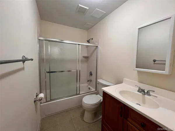 a bathroom with a granite countertop sink toilet a mirror and shower