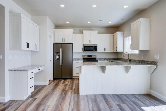 668 East Fiddlers Canyon Road, Unit 24 Cedar City, UT 84721 - Photo 3 of 21 Kitchen featuring stainless steel appliances, a breakfast bar, light stone countertops, a peninsula, and light wood-style floors