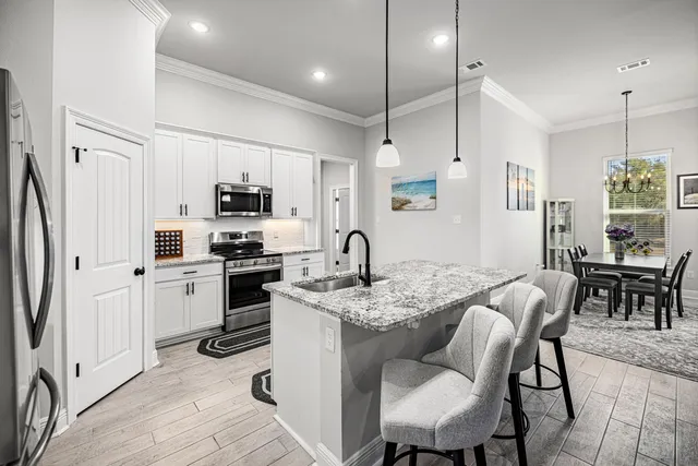 a kitchen with stainless steel appliances white cabinets and a stove top oven