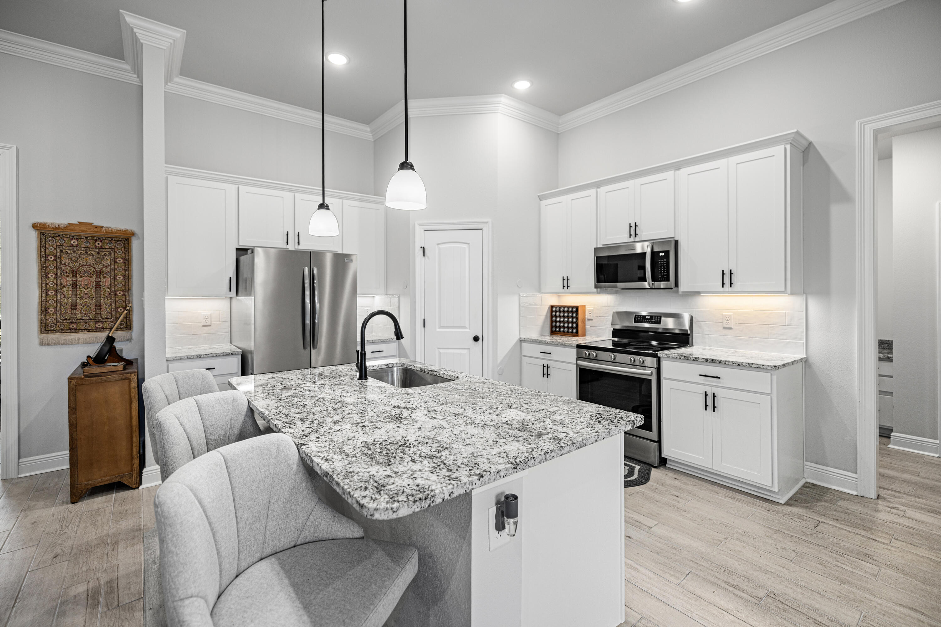 132 East Tweet Street Freeport, FL 32439 - Photo 14 of 79 a kitchen with granite countertop a stove a sink dishwasher a refrigerator and microwave with wooden floor