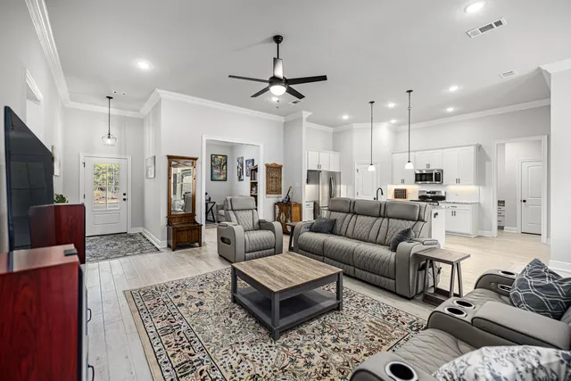 a kitchen with granite countertop a stove a sink dishwasher a refrigerator and microwave with wooden floor