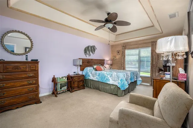 a bedroom with a bed a chandelier and dresser